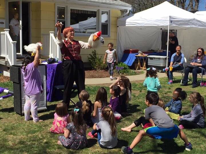Stephanie Beach surrounded by children during a birthday party magic show.